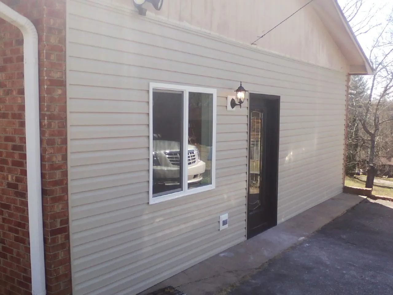 New vinyl siding and entry door on a room addition in Indian Lake Estates
