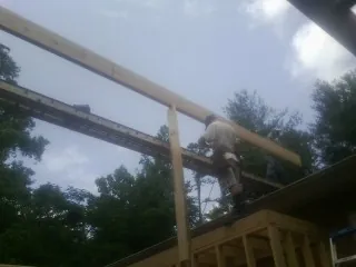 Carpenter setting a ridge beam over a new addition frame — Ice Dam Removal by Roofing Brothers in Indian Lake Estates