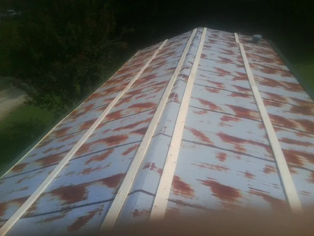 Rusted metal roof panels with new wood purlins before replacement — Storm Damage Roof Repair in Indian Lake Estates by Roofing Brothers