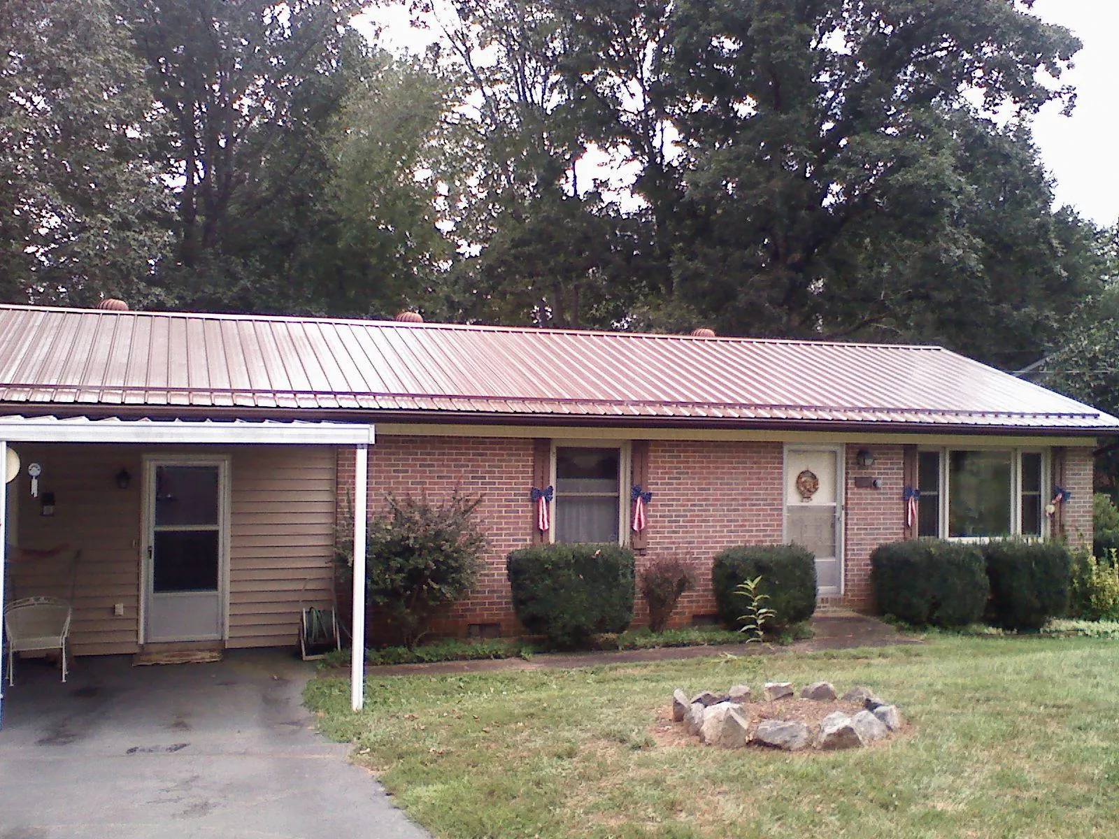 Bronze metal roof and carport on a brick ranch home — Roof Repair work by our crew in Indian Lake Estates